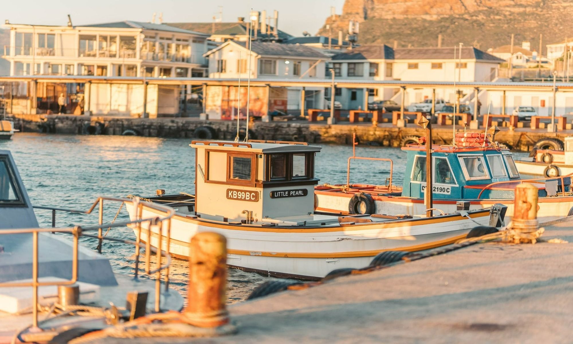 boats parked beside the dock with buildings surrounding the lake