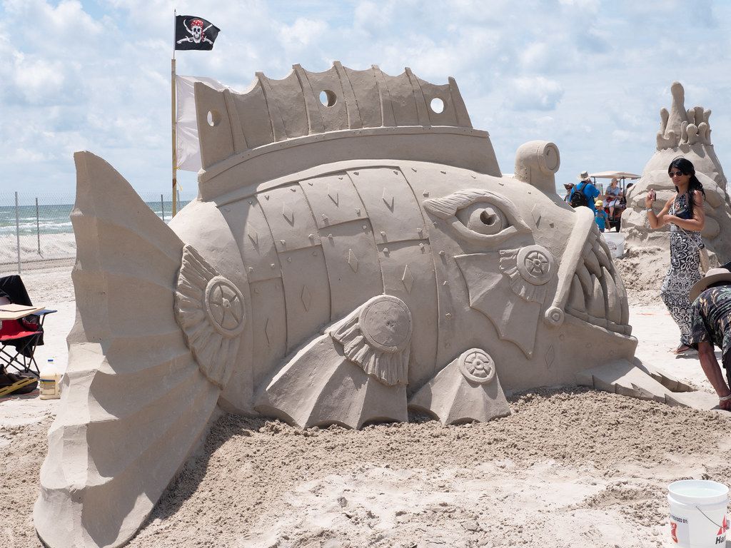 Woman looking at a giant fish made from sand at the Port Aransas sandfest