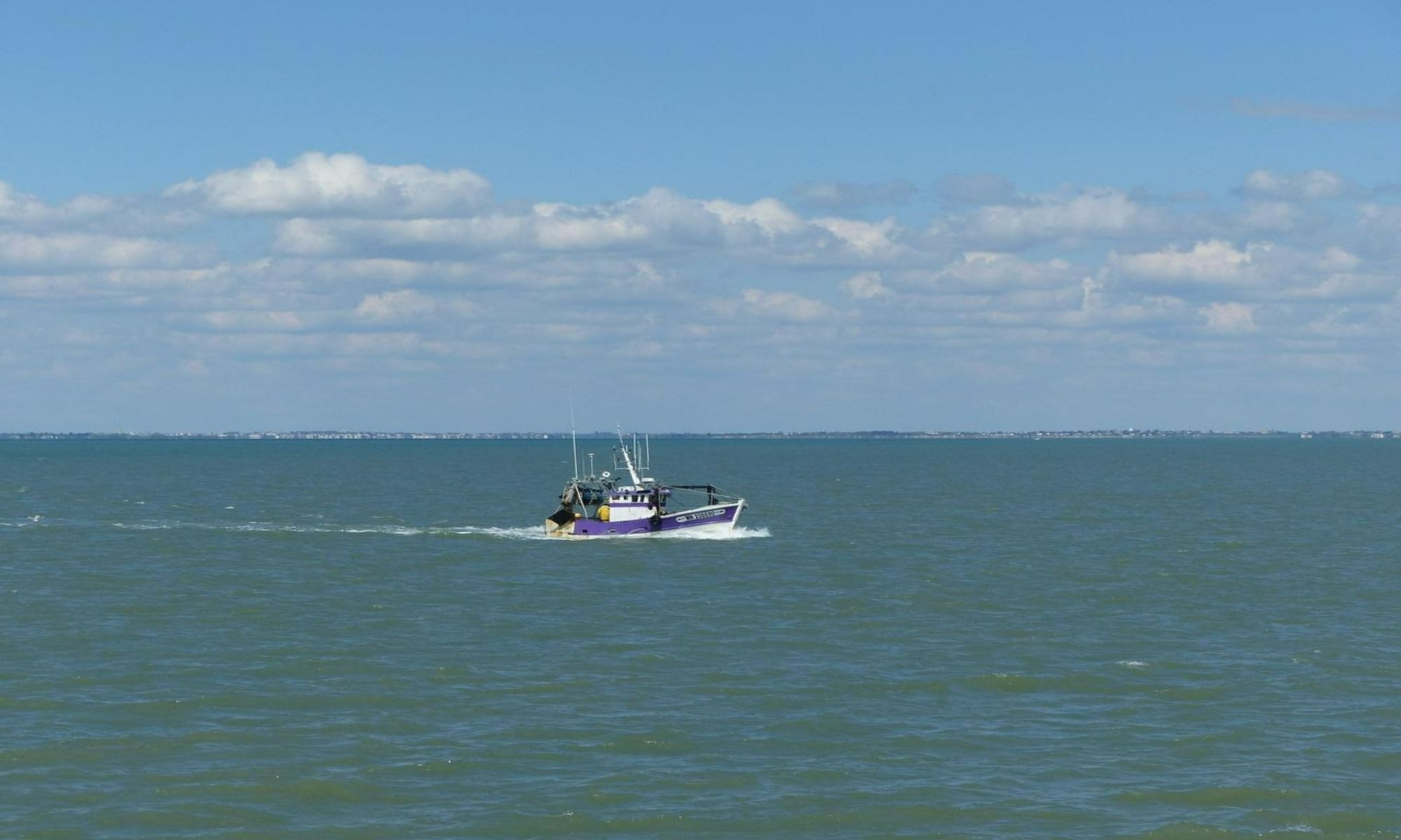 fishing boat in the middle of the water body