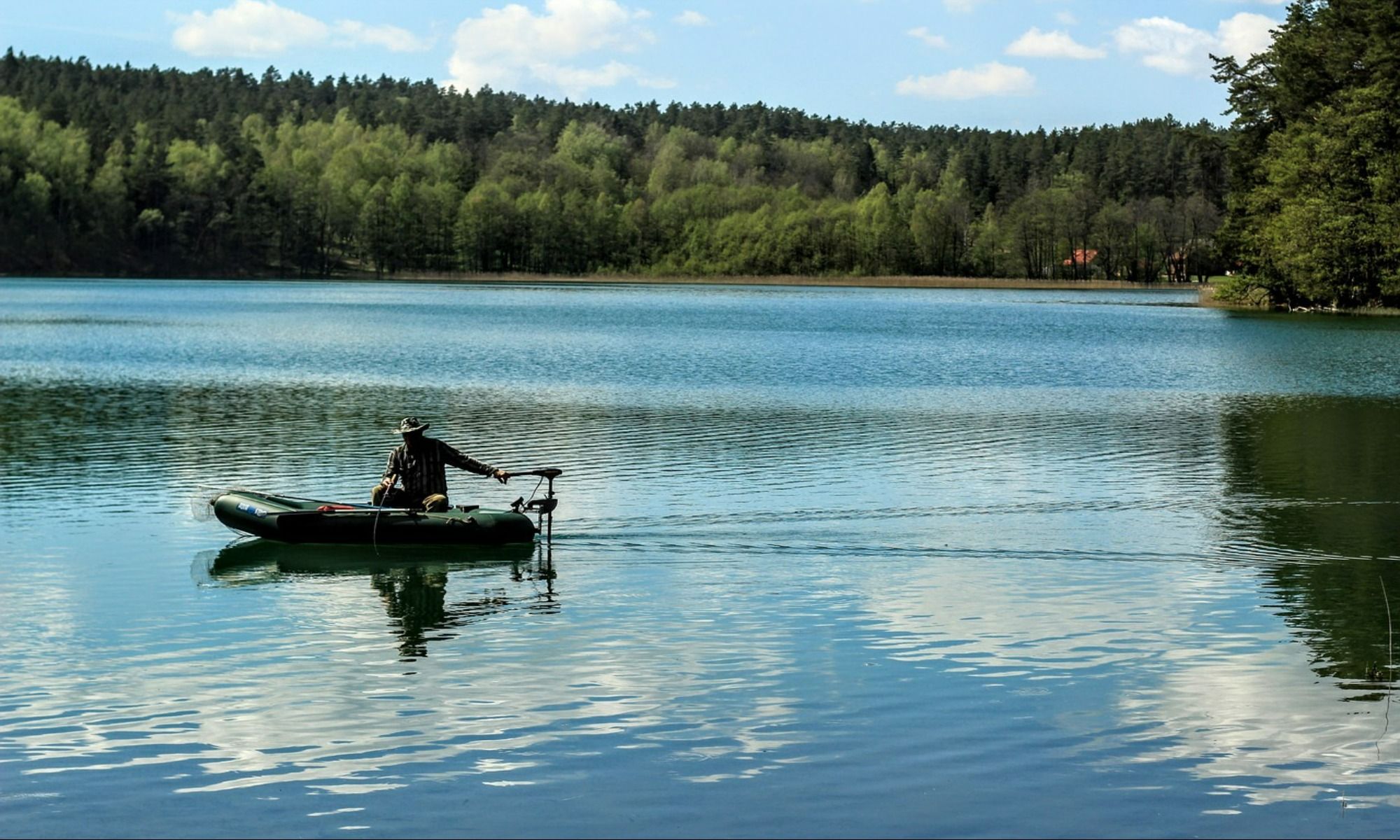 man on a belly boat fishing on the lake