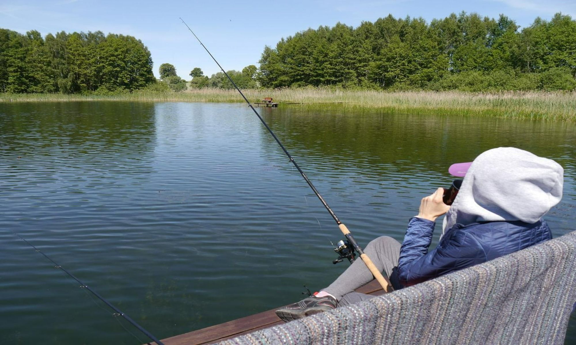 a woman peacefully fishing by the lake