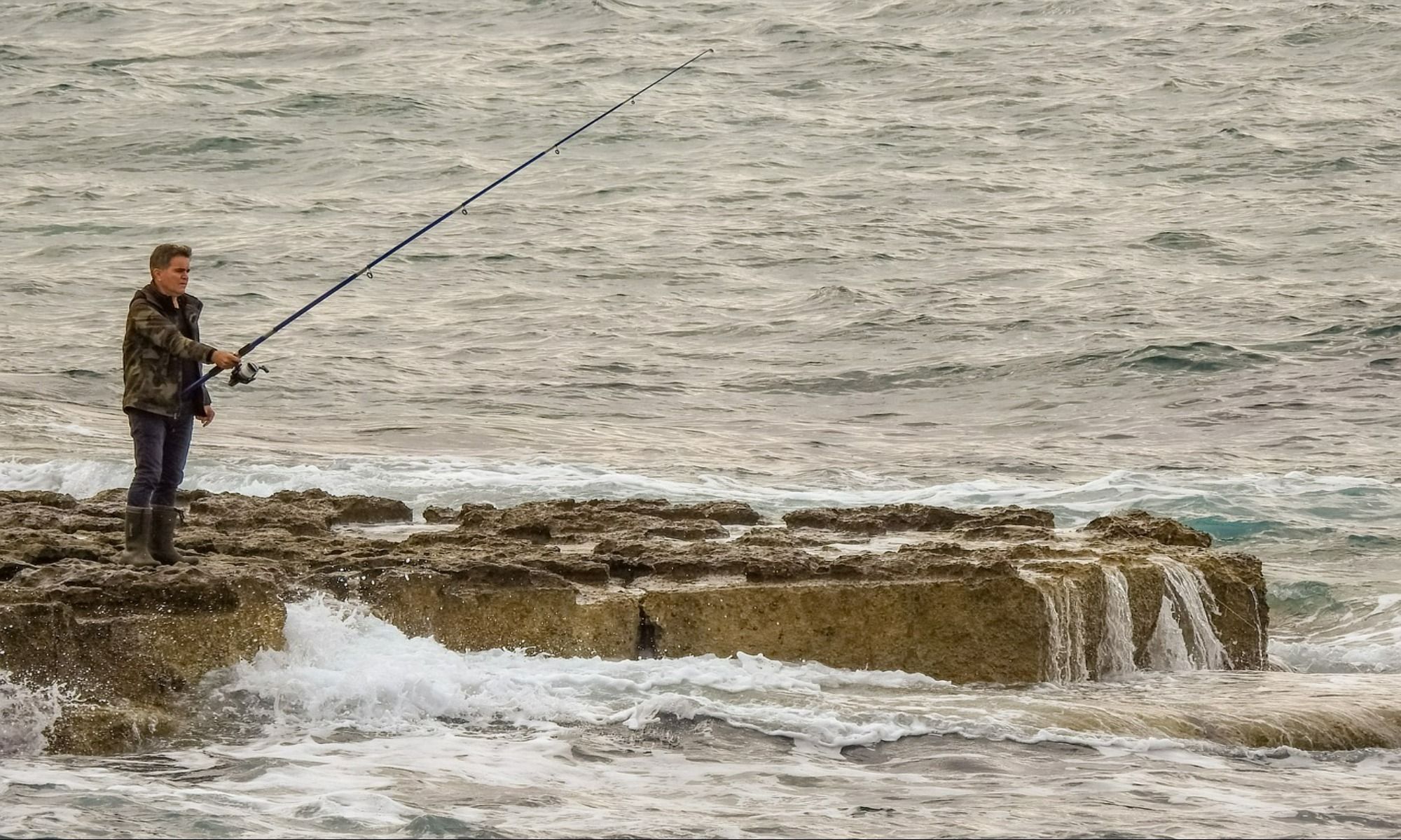 man fishing by the water body