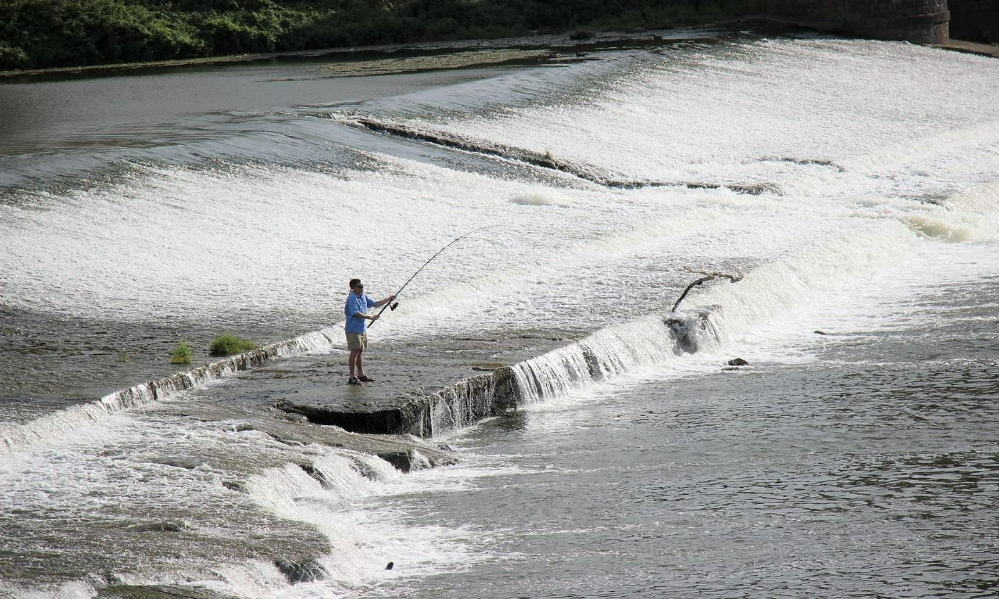 a man in the middle of the river, fishing