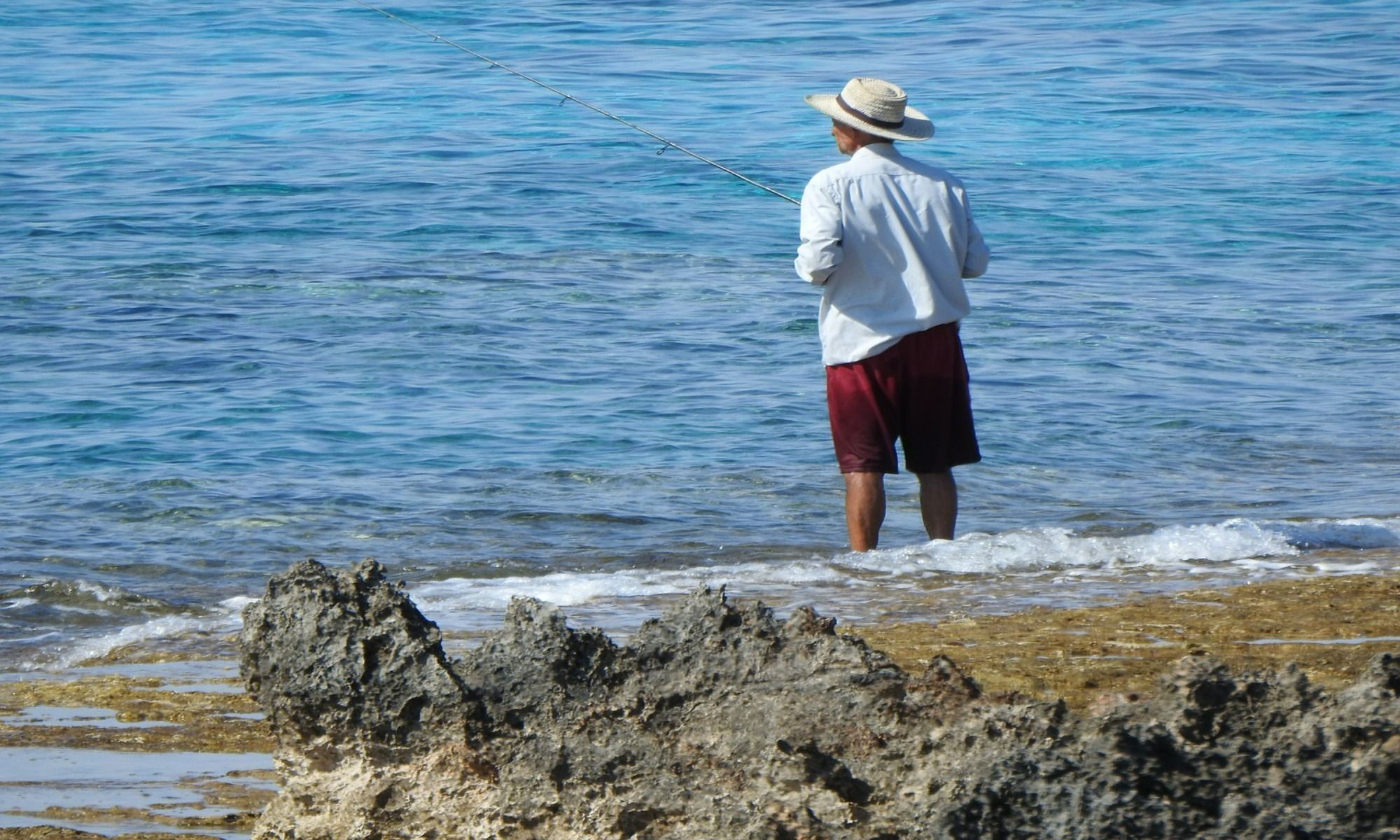 a man fishing by the beach 