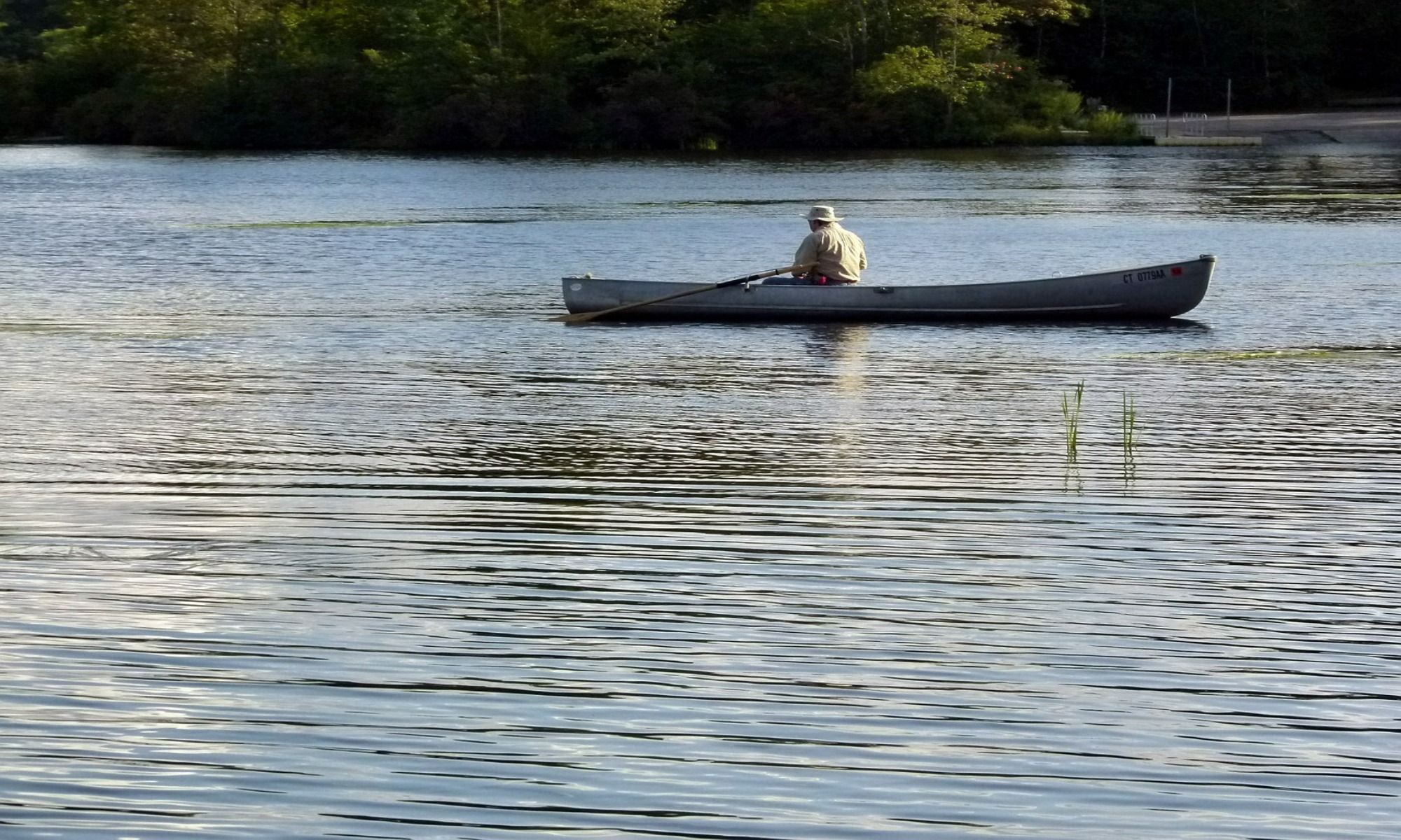 a man rowing a small boat on the lake